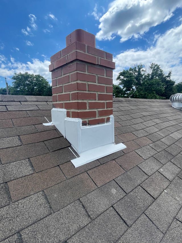 Rebuilt brick chimney with new flashing on a shingle roof