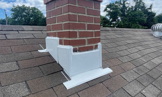 Rebuilt brick chimney with new flashing on a shingle roof