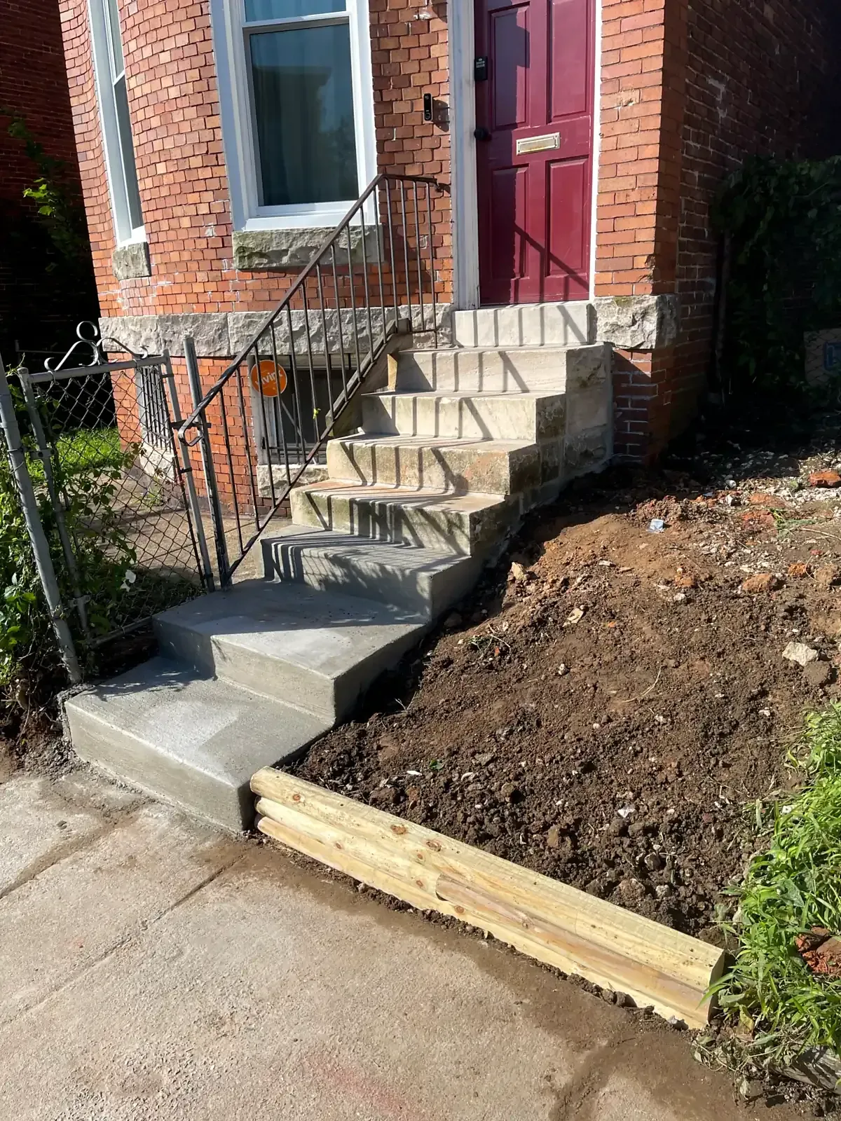 New concrete steps poured below the original stone steps of a Baltimore rowhouse