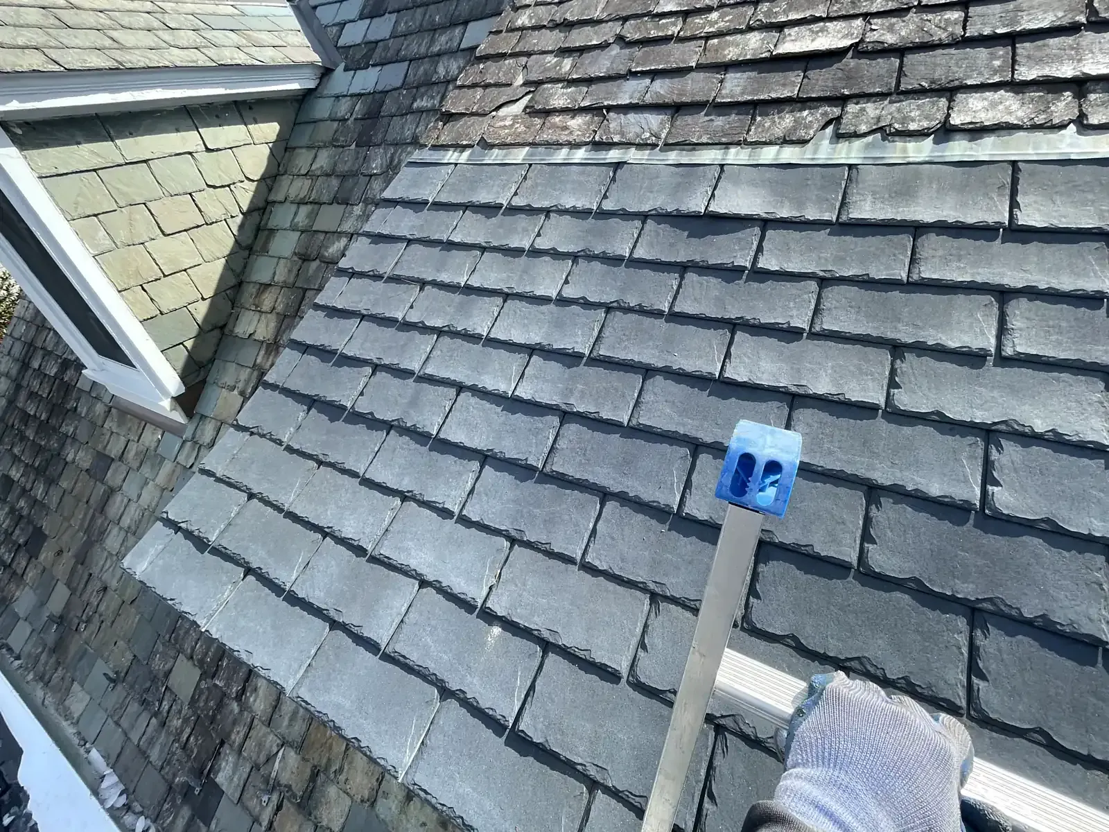 Slate roof next to a dormer where we reinstalled leaking synthetic slates someone else put in