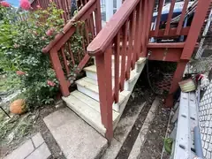 Back deck stairs with new wood treads beside the existing railing