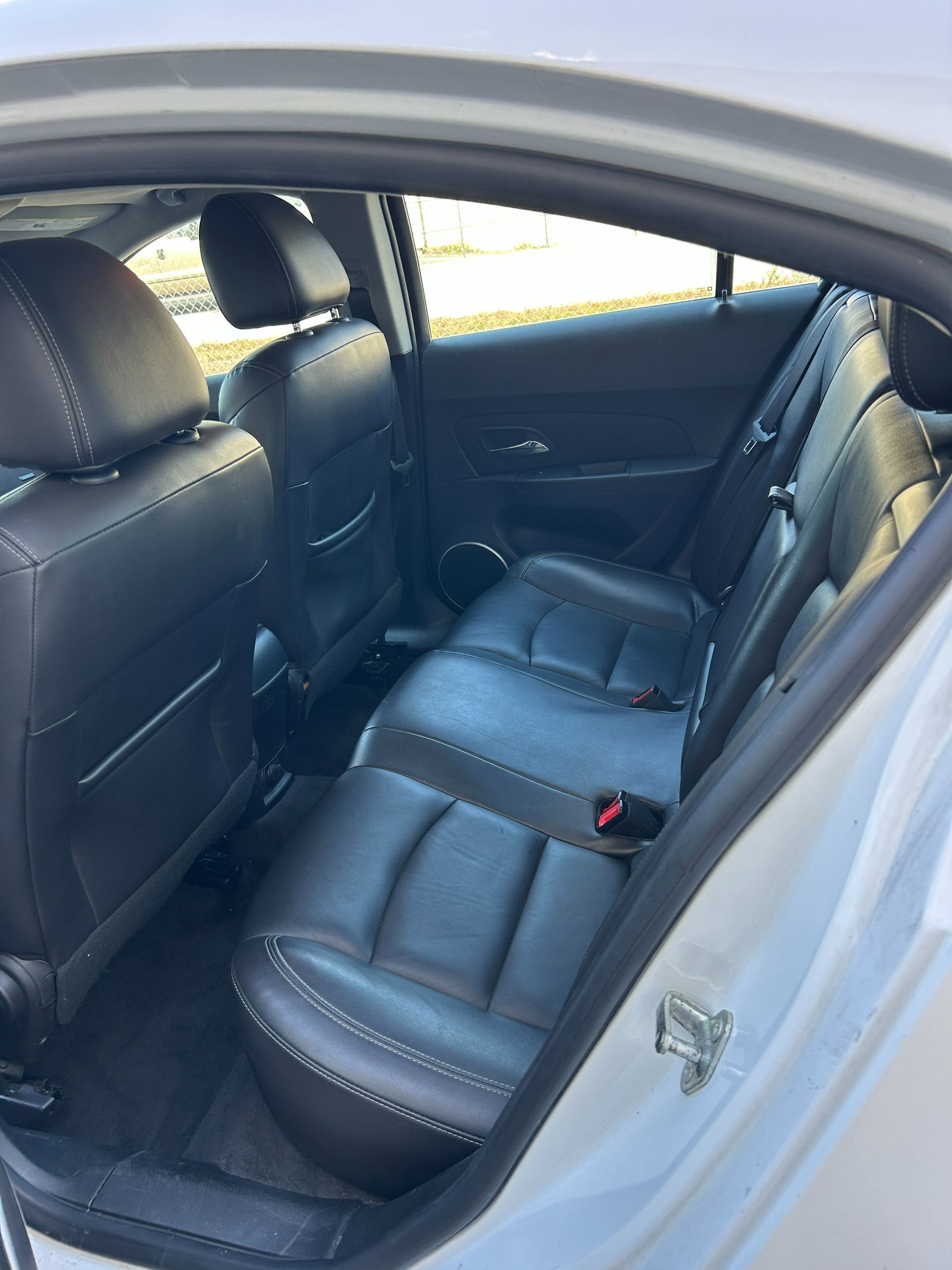 Car interior with black leather rear seats and open rear door
