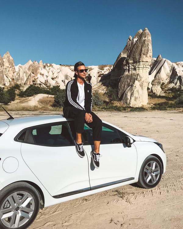 man sitting on top of a car