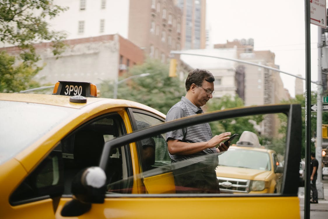 pensive man leaned against the yellow car