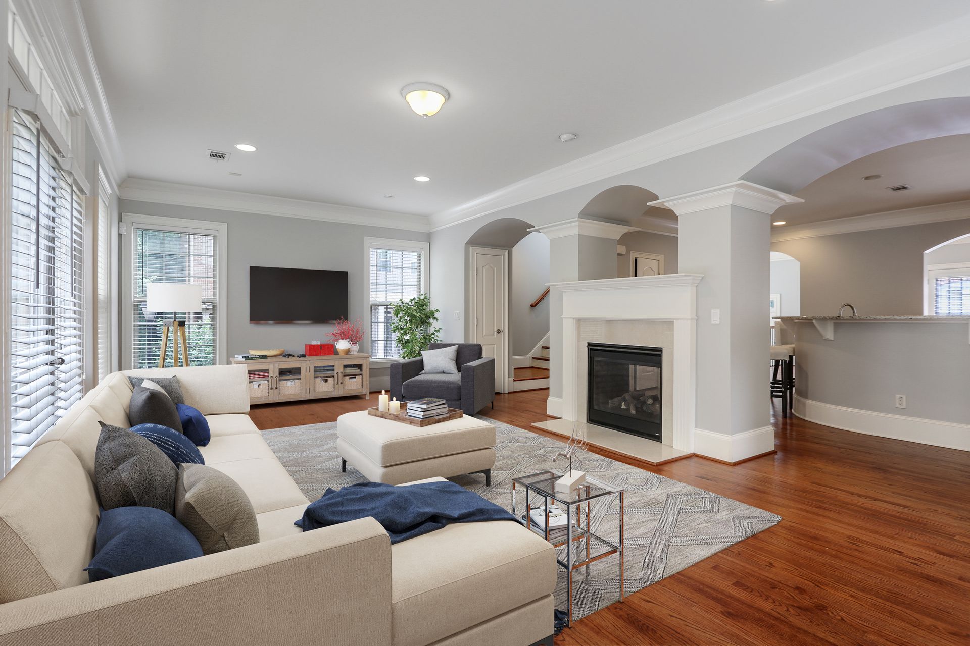 A living room with a couch , chair , television and fireplace.