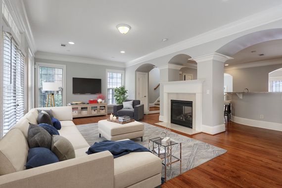 A living room with a couch , chair , television and fireplace.