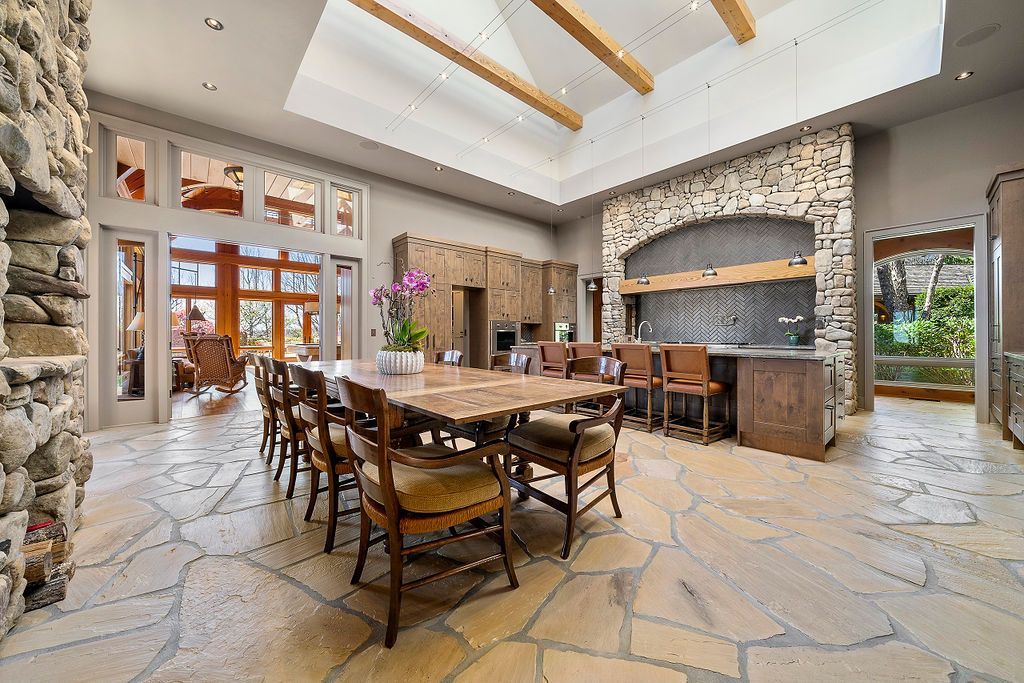 A large dining room with a wooden table and chairs and a stone floor.
