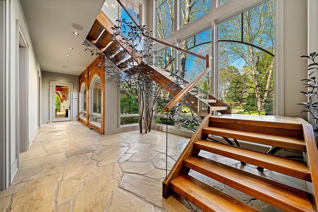 A wooden staircase in a hallway with lots of windows
