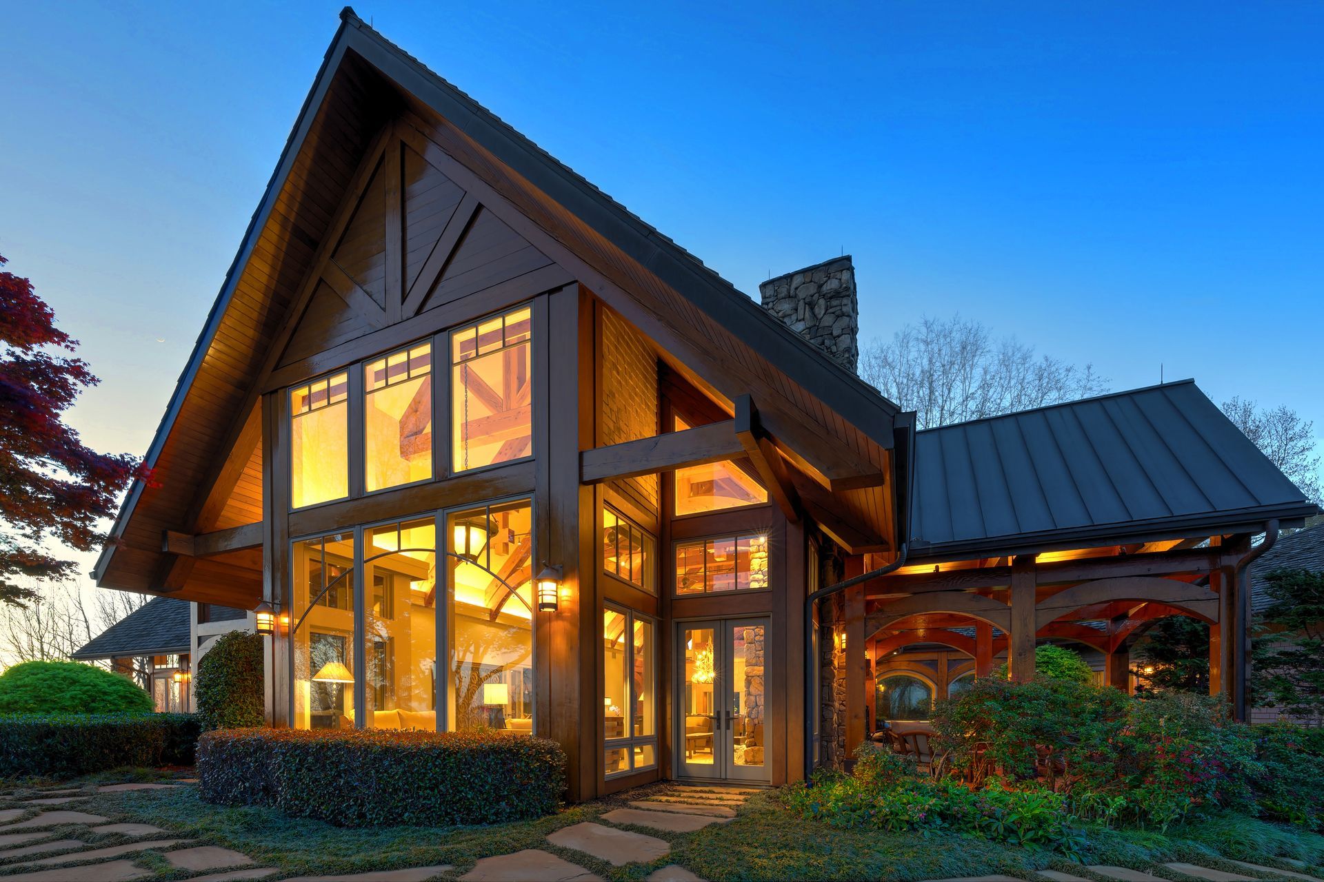 A large house with a lot of windows is lit up at night.