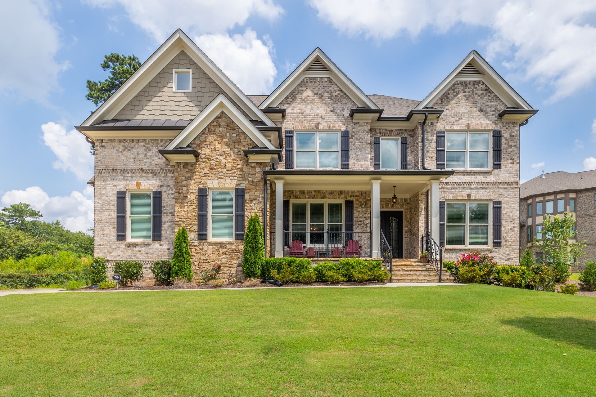 A large brick house with a large lawn in front of it.