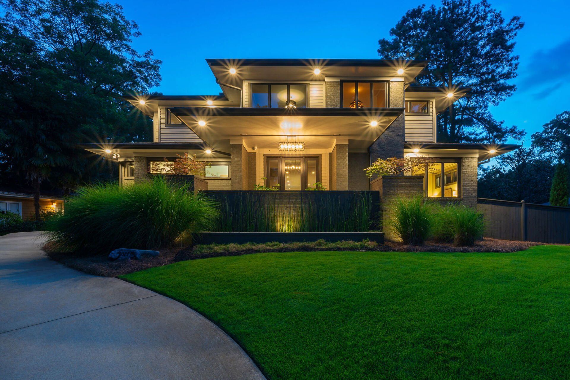 A large house with a lot of windows is lit up at night
