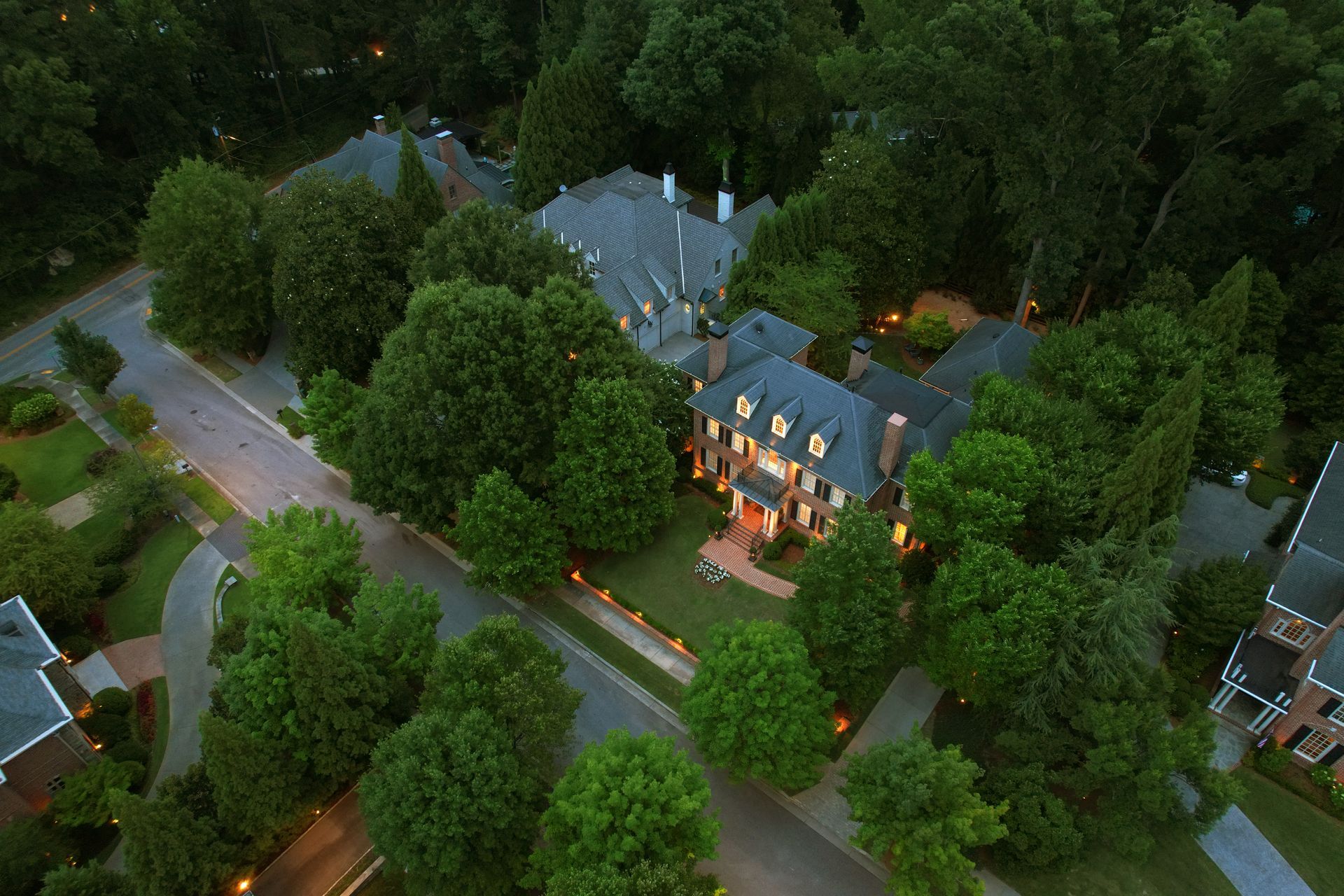 An aerial view of a large house surrounded by trees.