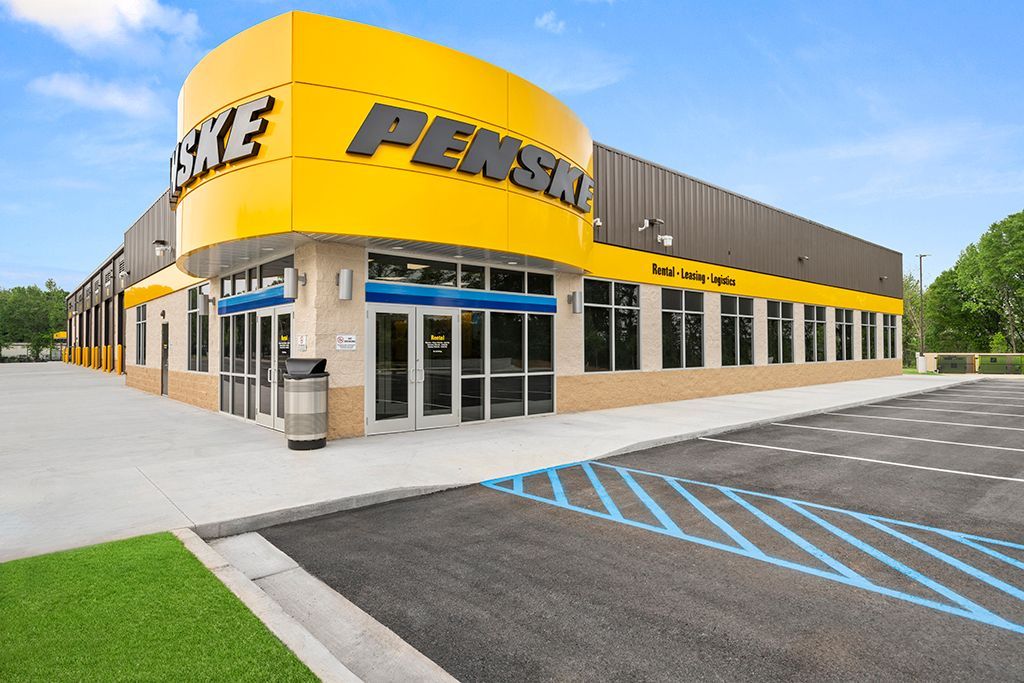 Penske truck rental building with yellow and black signage, blue parking lines.