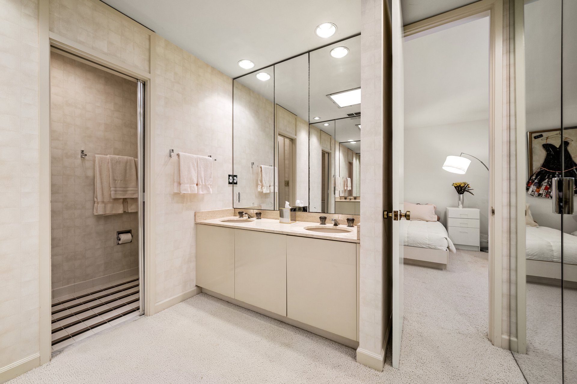 A bathroom with two sinks and a walk in shower