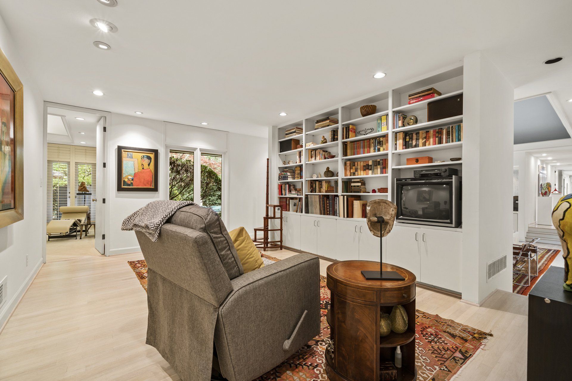 A living room with a couch , chair , table and bookshelf.