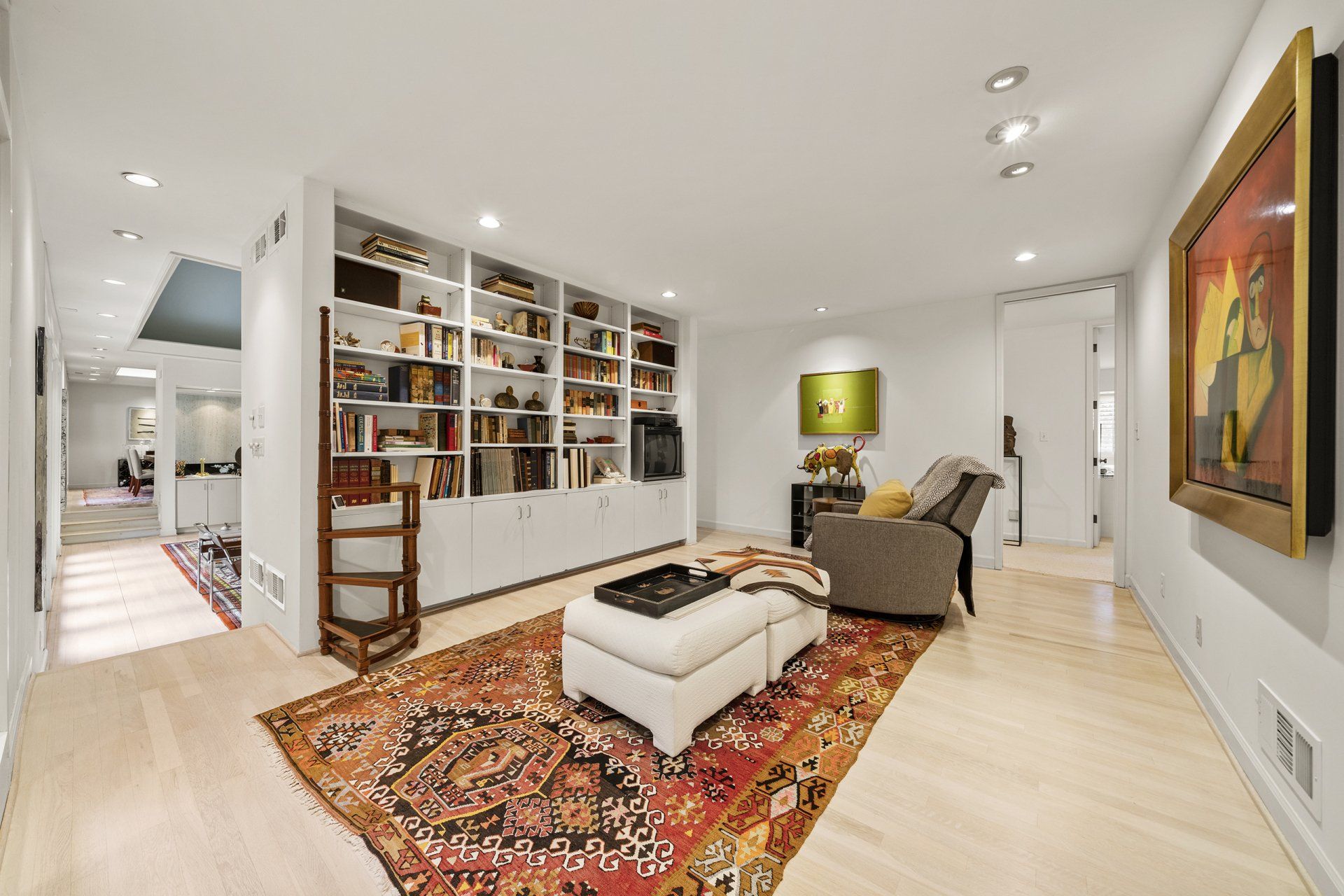 A living room with a couch , chair , ottoman and rug.