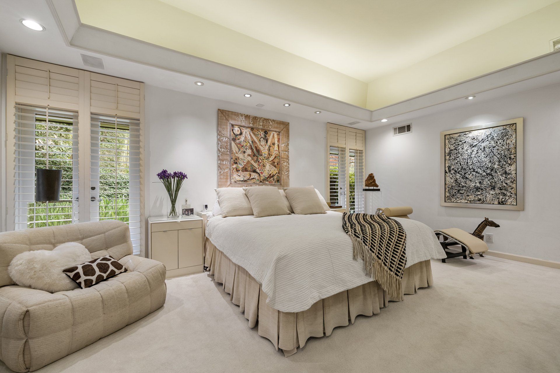 A bedroom with a large bed and a chair