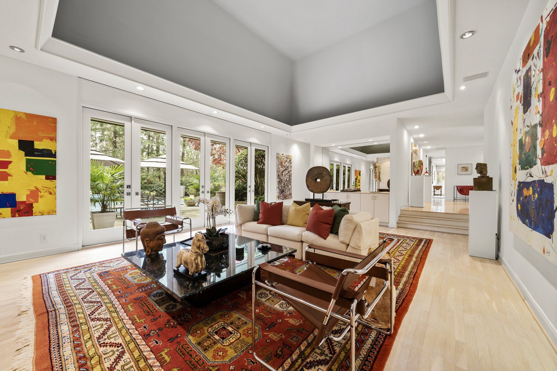 A living room with a couch , chairs , a coffee table and a rug.