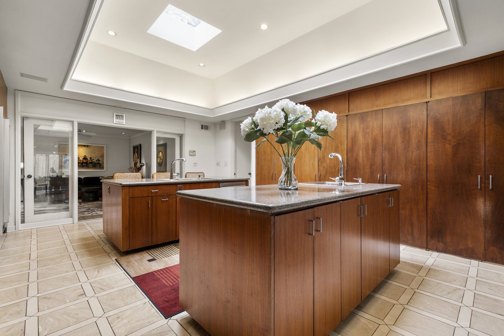 A kitchen with a large island and a vase of flowers on the counter.