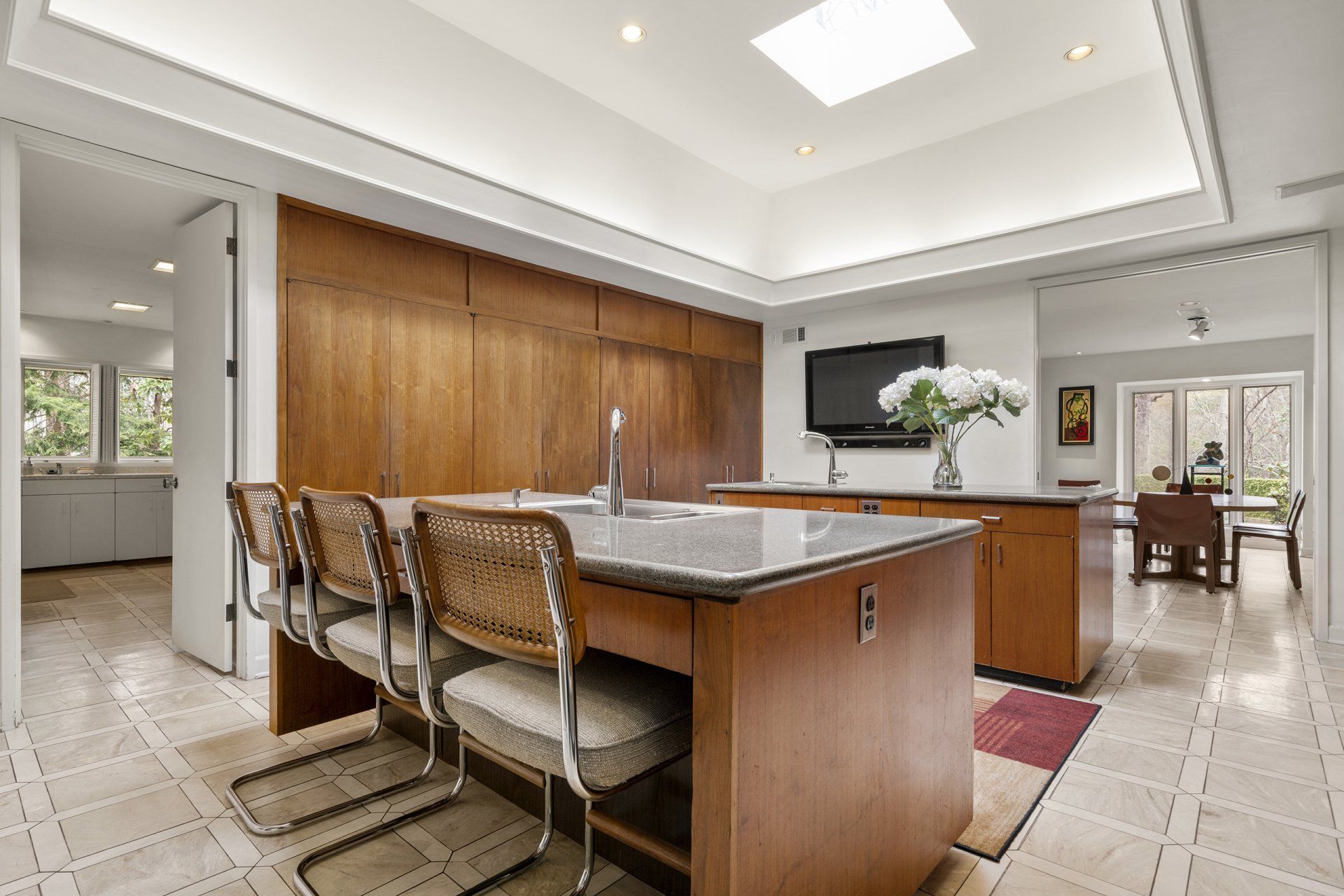 A kitchen with a large island and a television on the wall.
