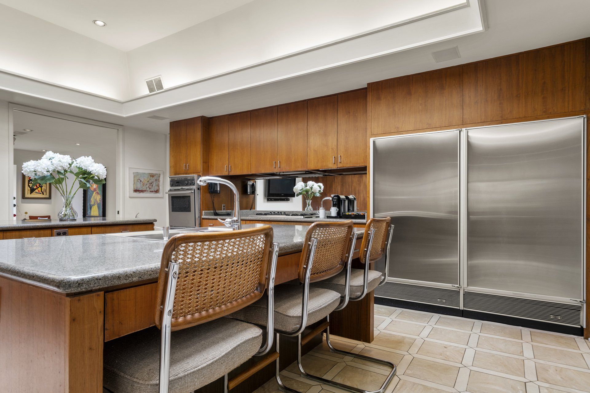 A kitchen with stainless steel appliances , granite counter tops , and wooden cabinets.