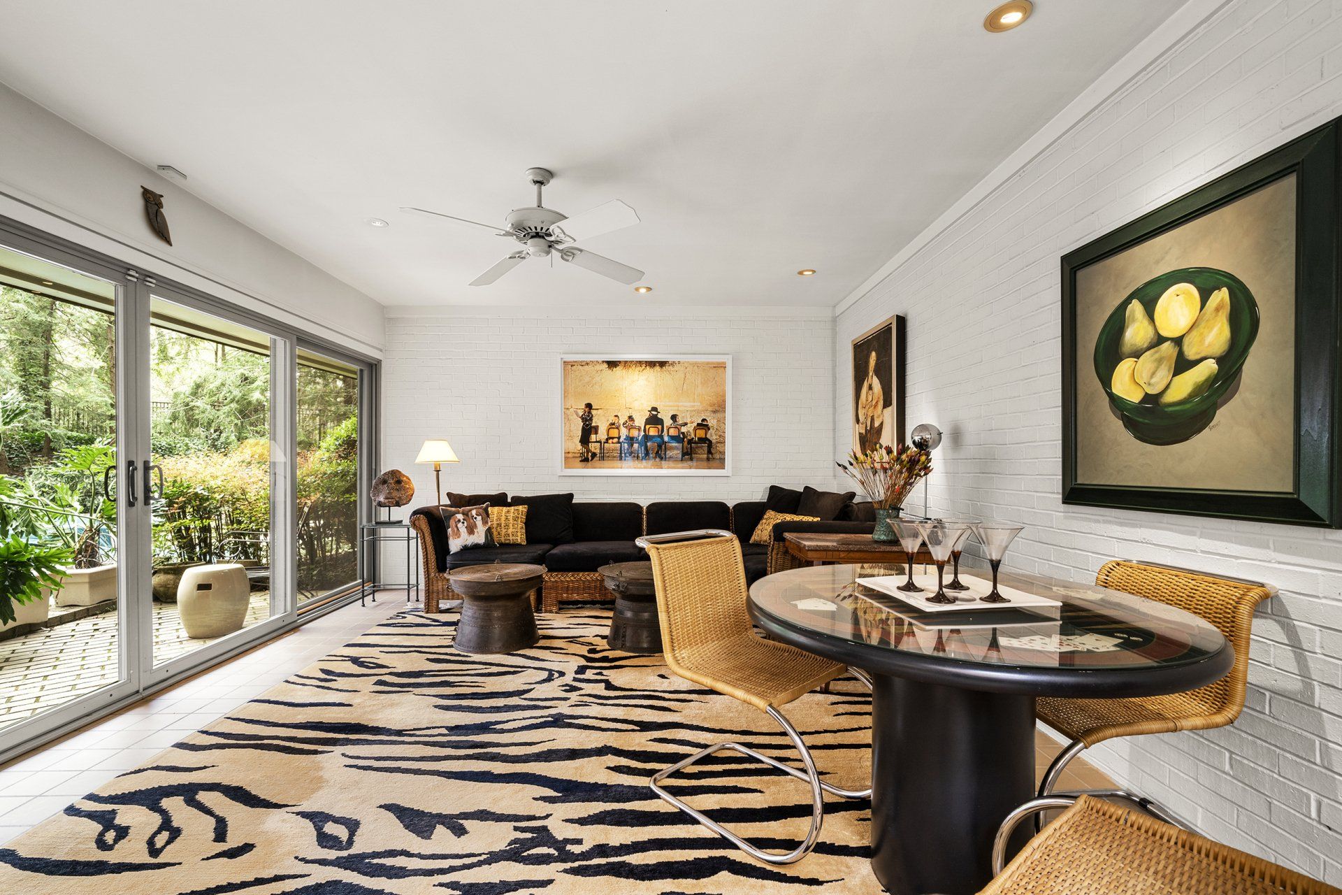 A living room with a table and chairs and a ceiling fan