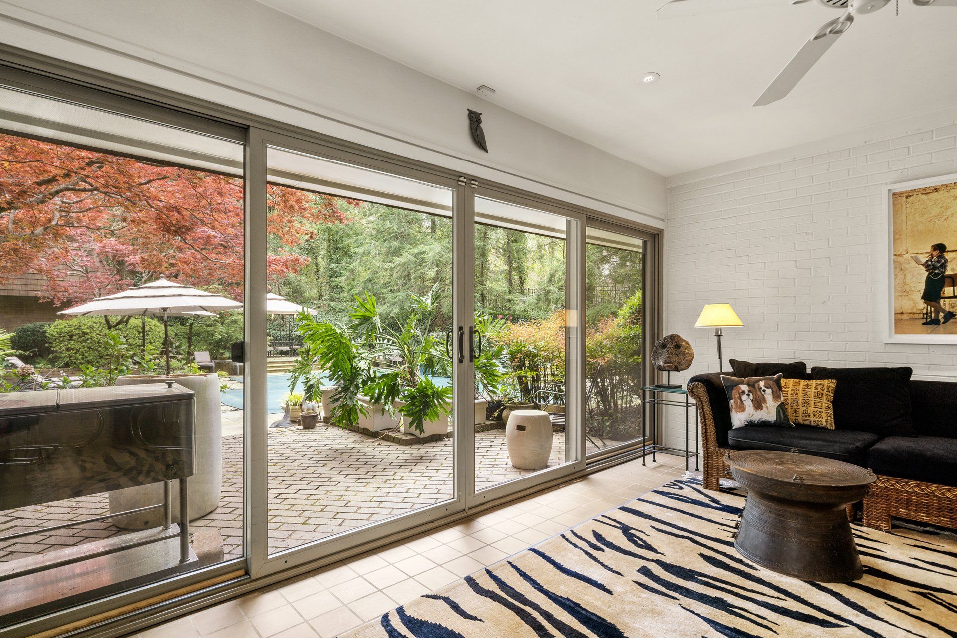 A living room with a couch , table , and sliding glass doors leading to a patio.