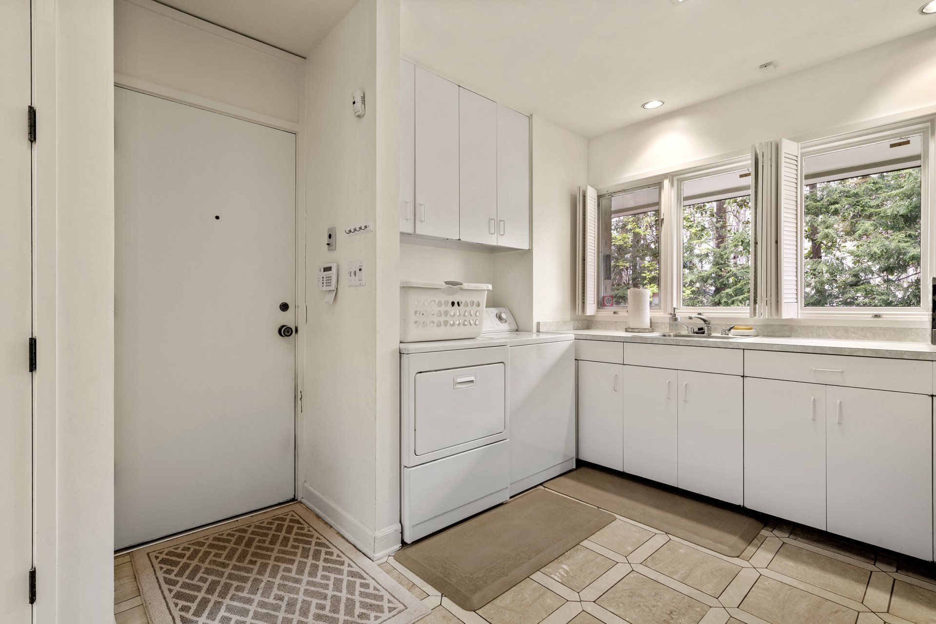 A laundry room with white cabinets and a washer and dryer