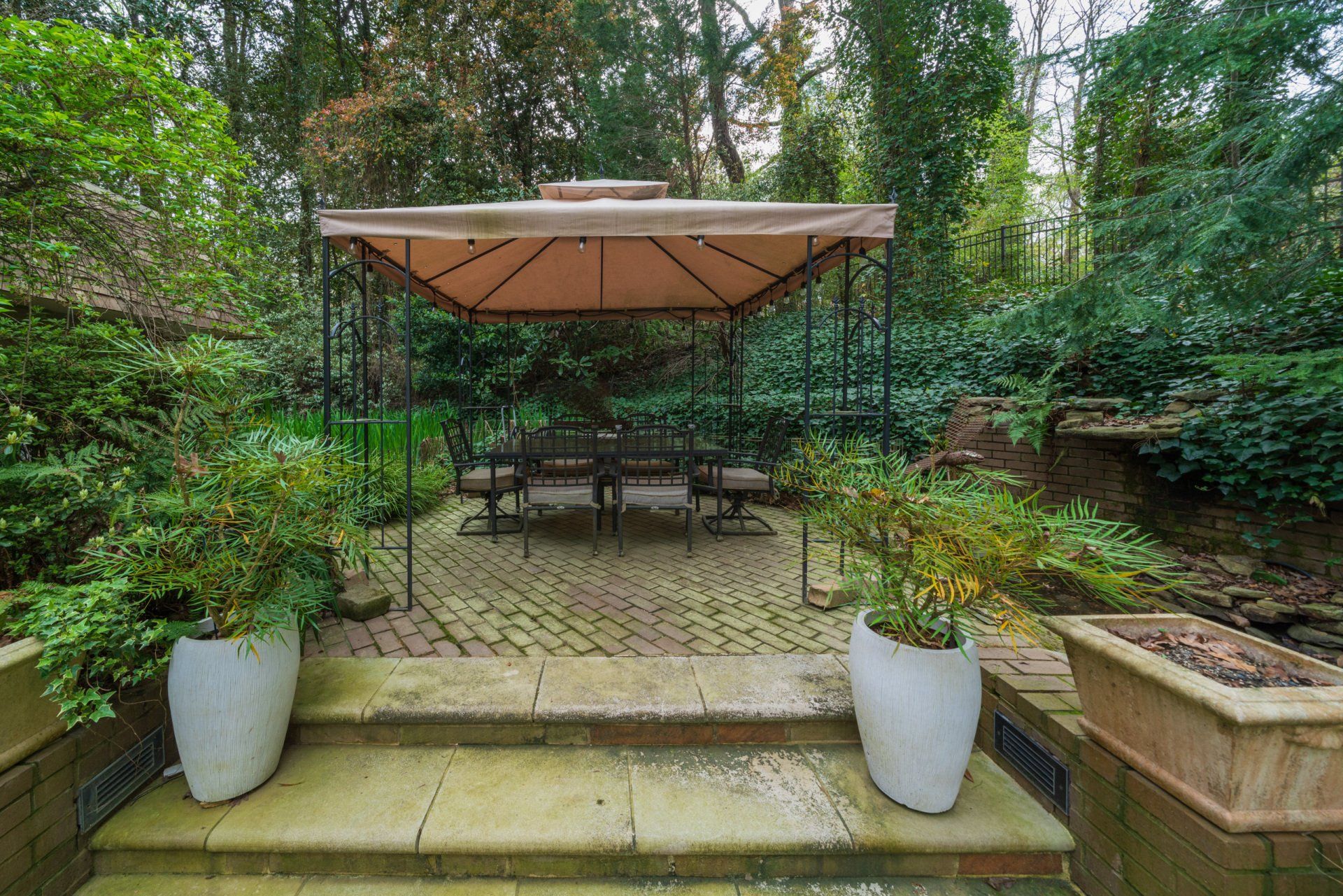 There is a gazebo with a table and chairs in the backyard.