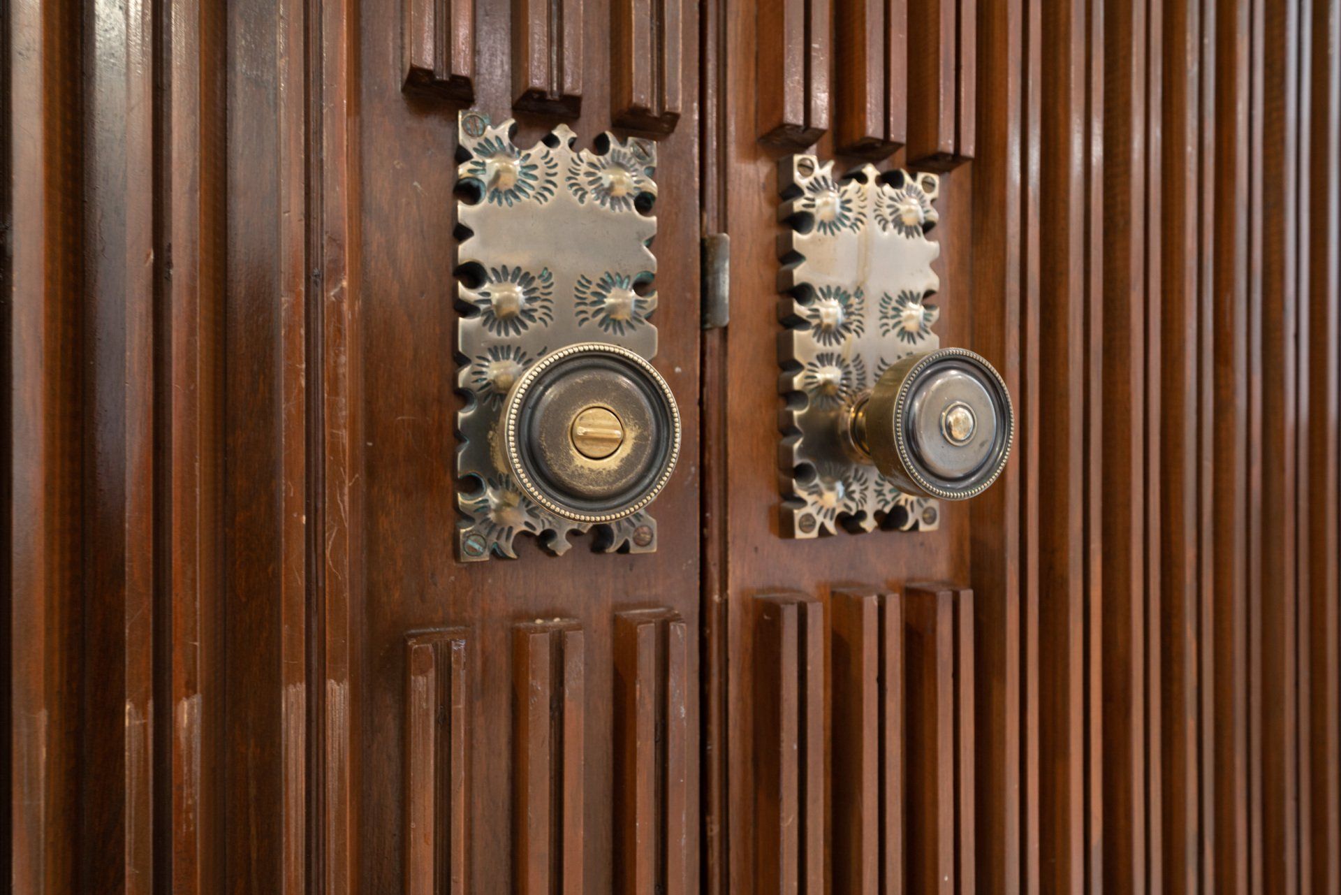 A pair of door knobs on a wooden door.