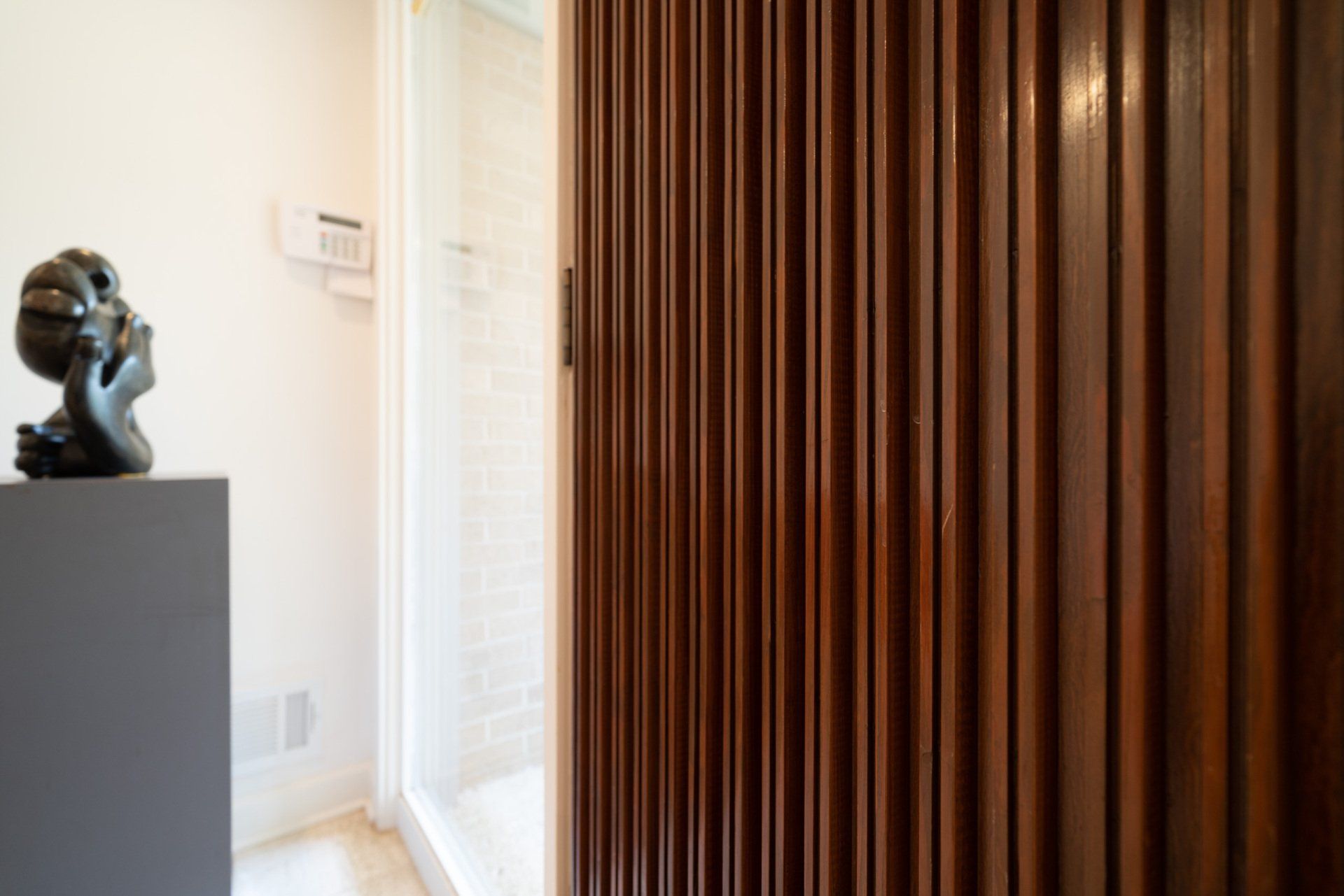 A statue is sitting on a shelf next to a wooden wall.