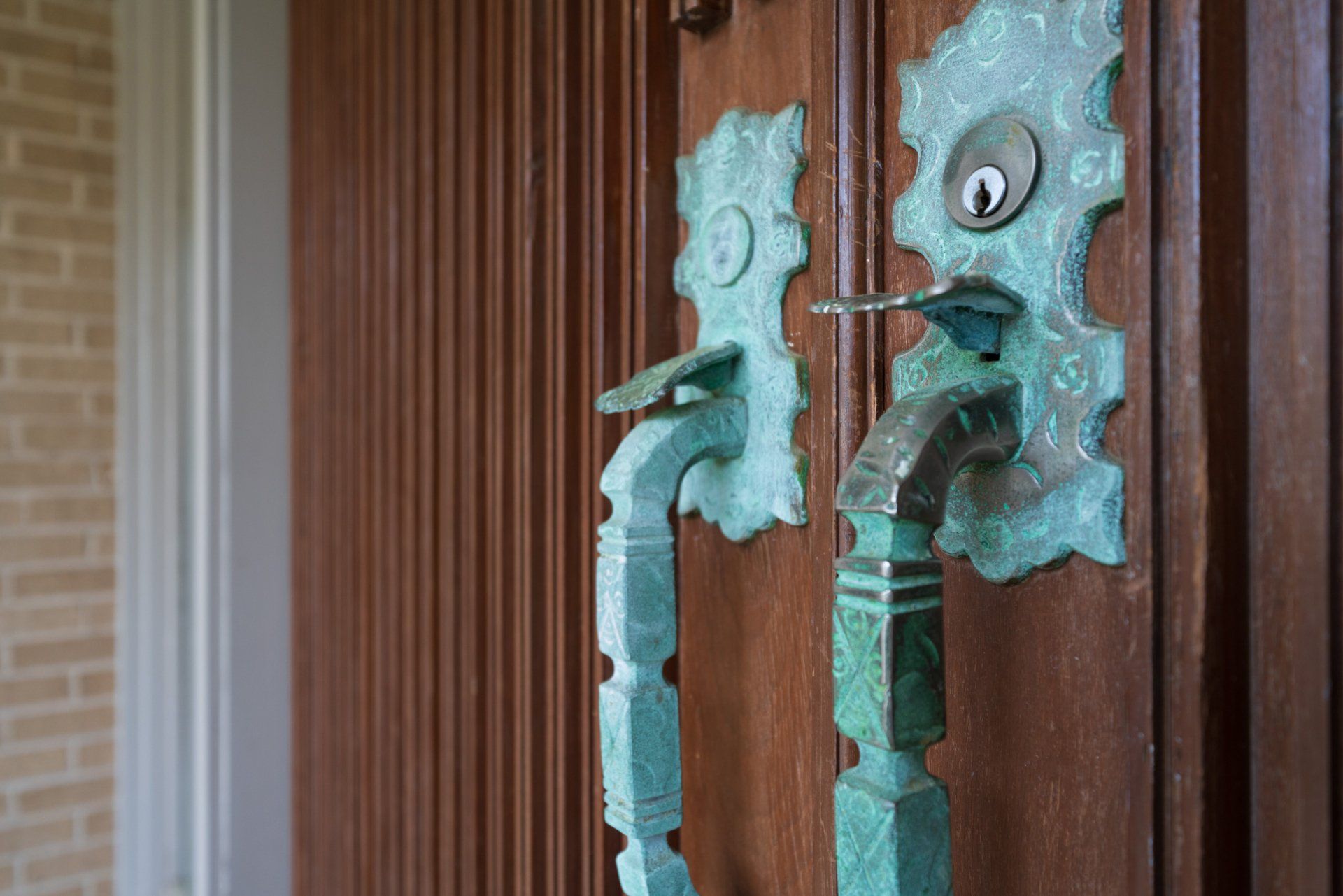 A close up of a door handle on a wooden door.
