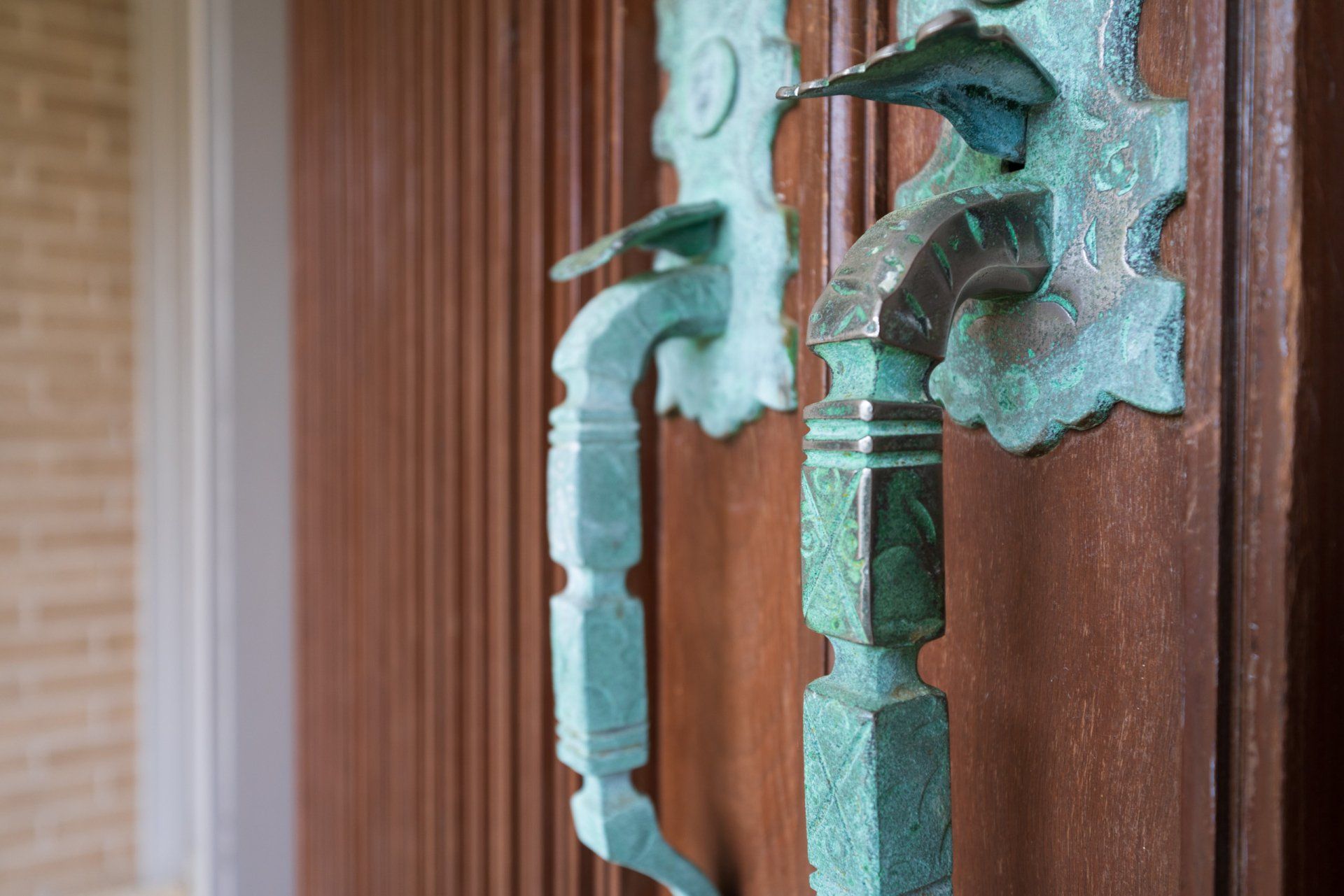 A close up of a door handle on a wooden door.