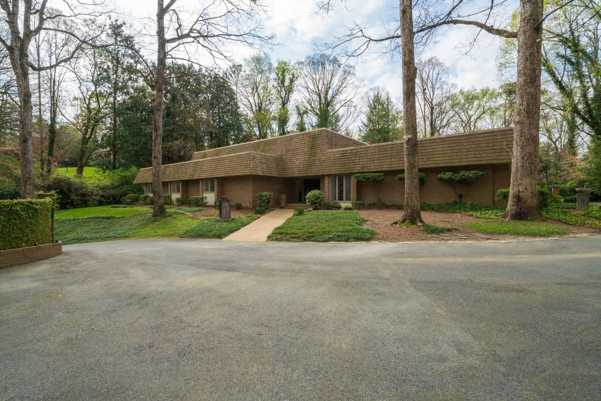 A large house with a roof that is surrounded by trees