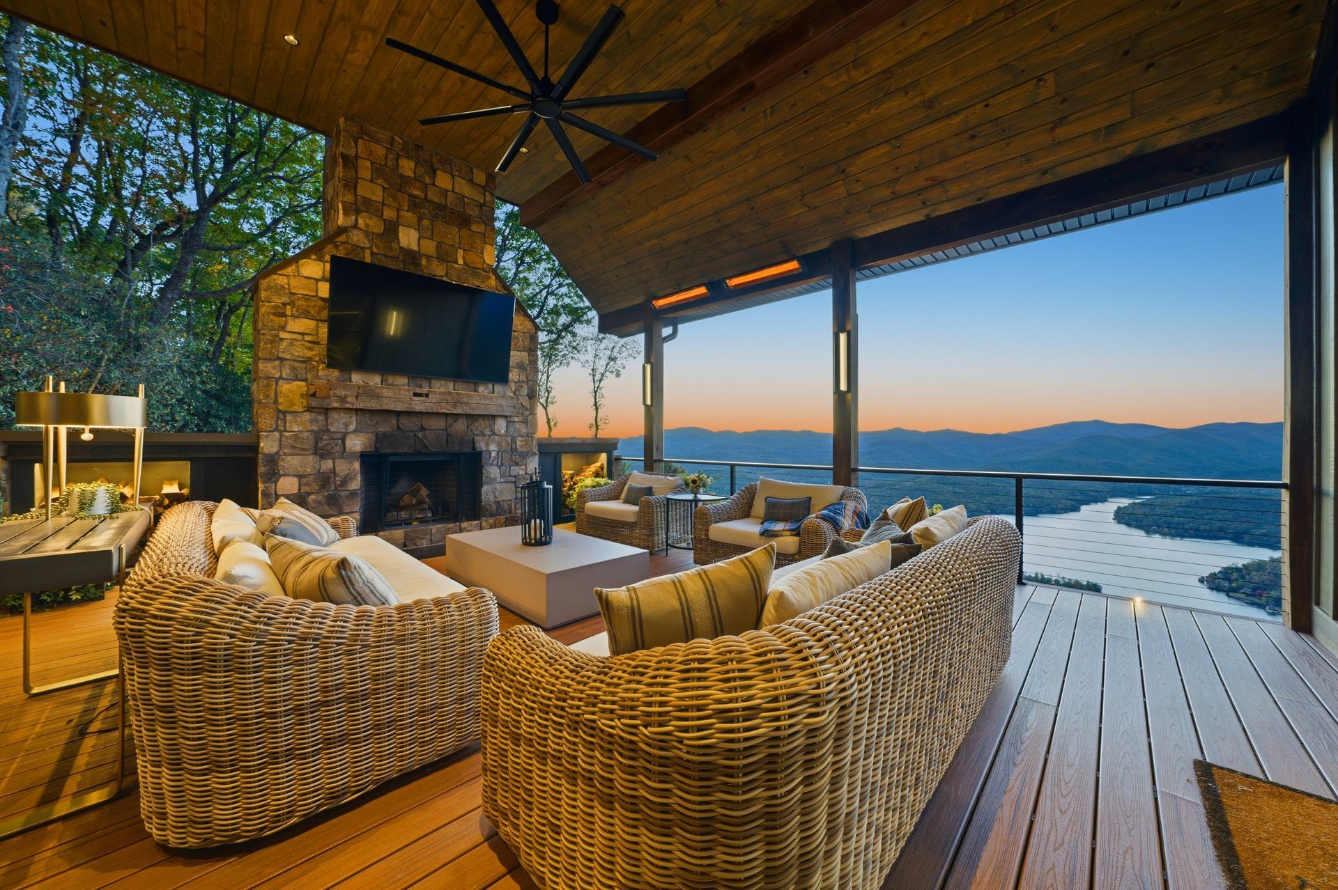 A living room with a couch , chair , television and fireplace.