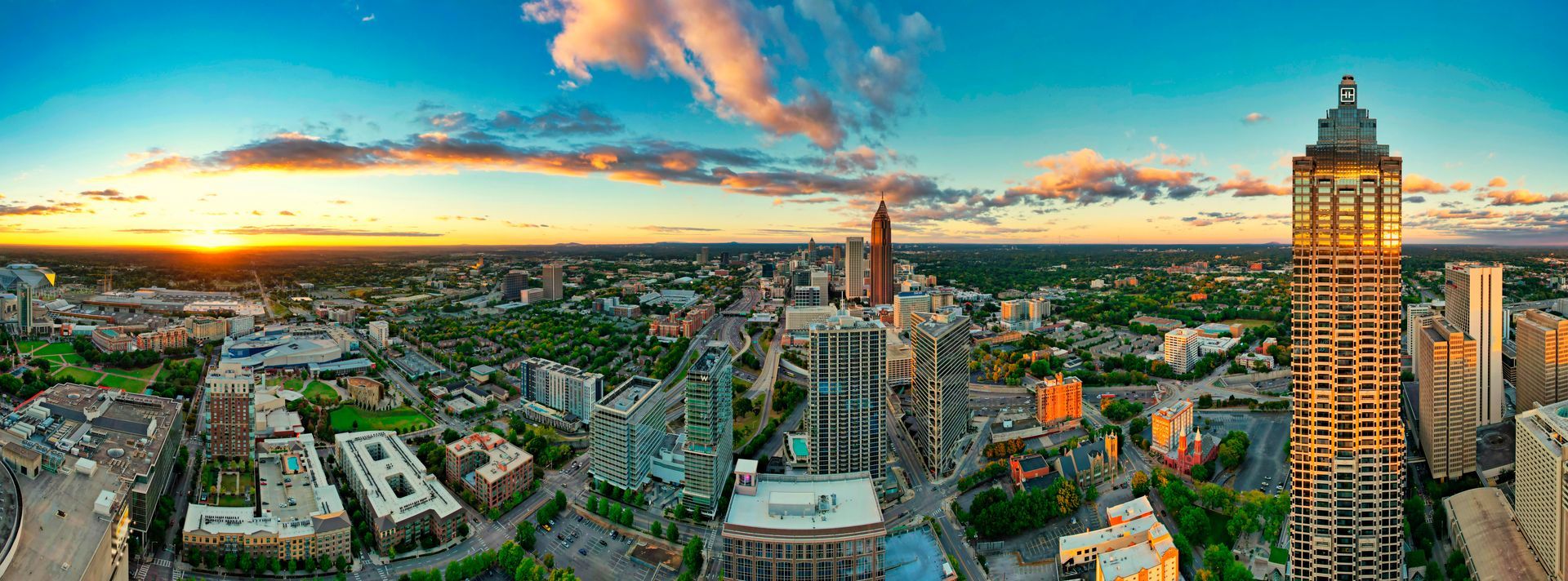 An aerial view of a city with a sunset in the background.