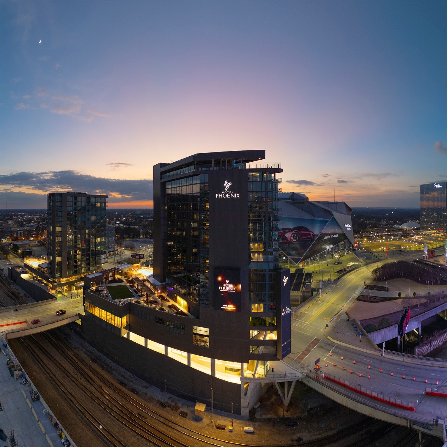 Hotel Phoenix at dusk, with Mercedes-Benz Stadium visible in the background, in Centennial Yards in Atlanta, GA.