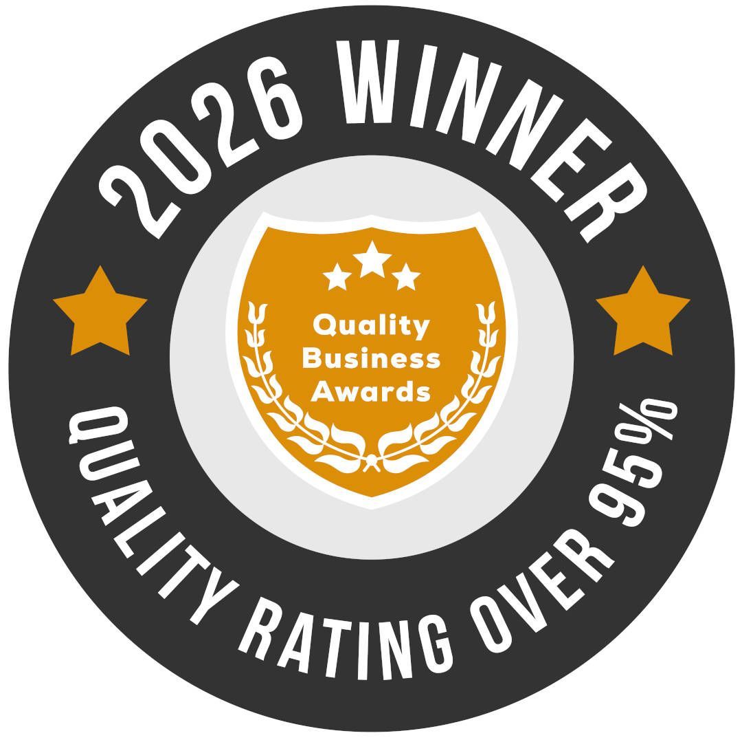 Gold laurel award emblem reading “Quality Business Awards 2026” with stars and podium base