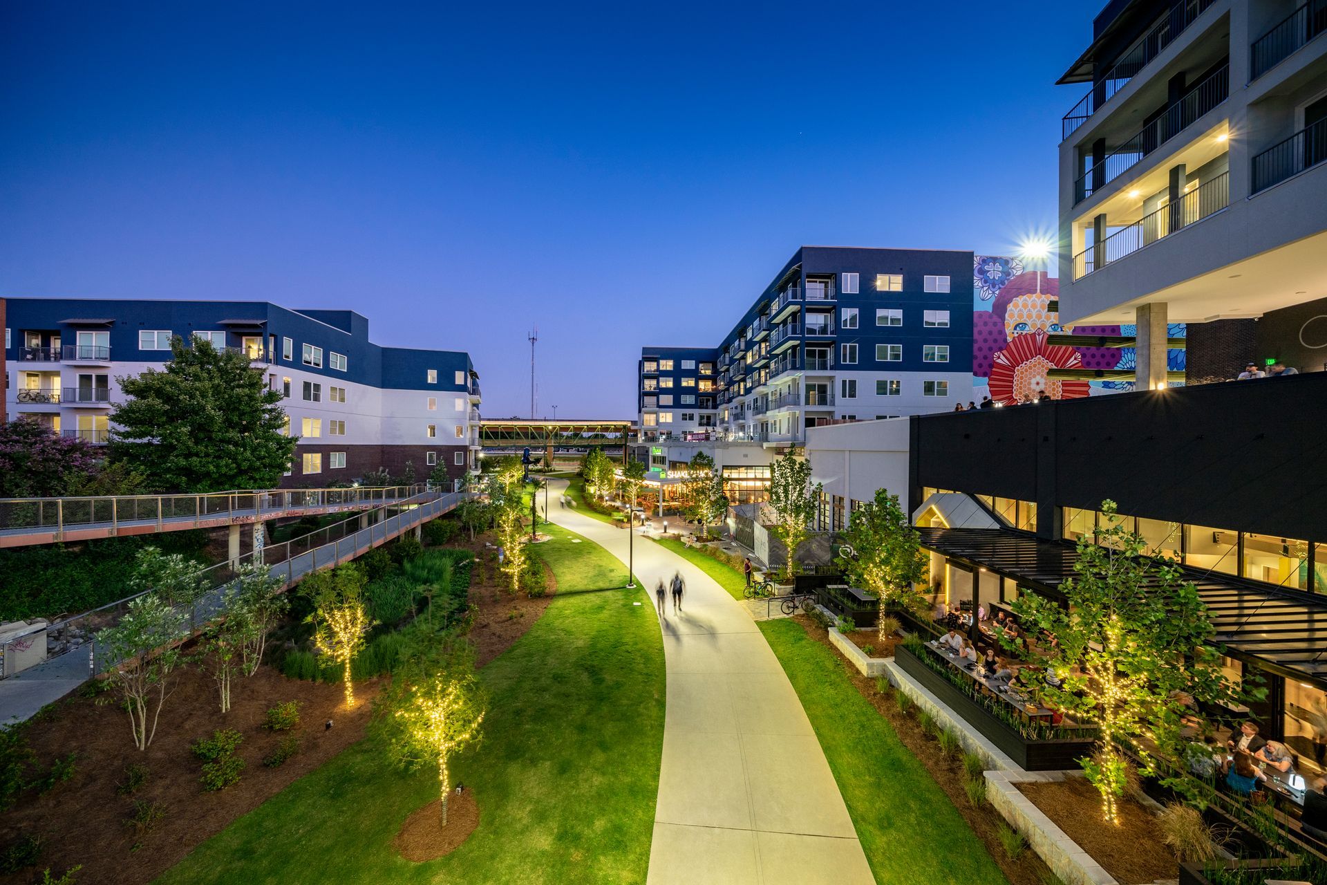 A group of people are walking down a path in an apartment community in Alpharetta, GA