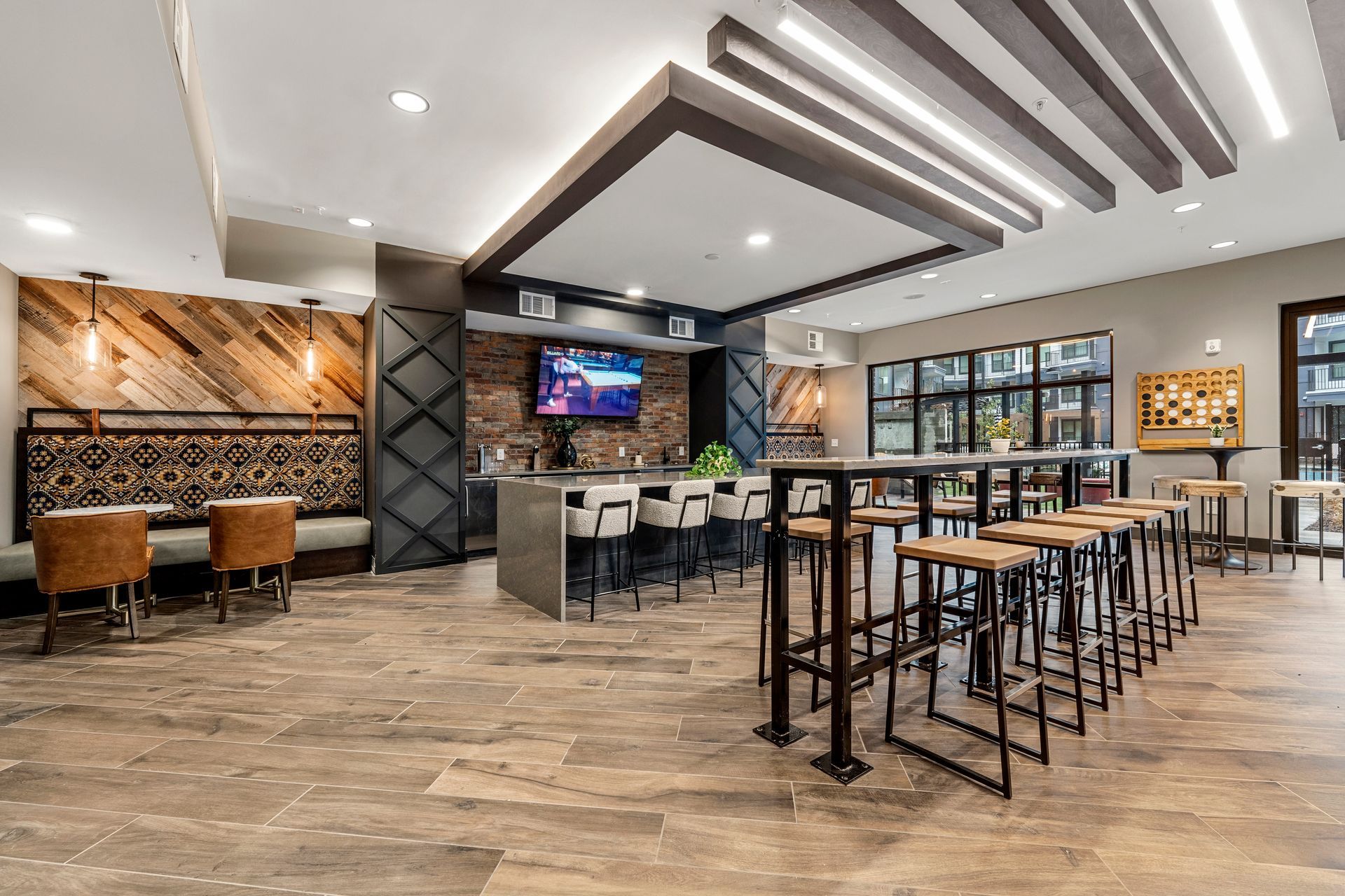 Bar area with wood accents, seating, bar stools, and a television.