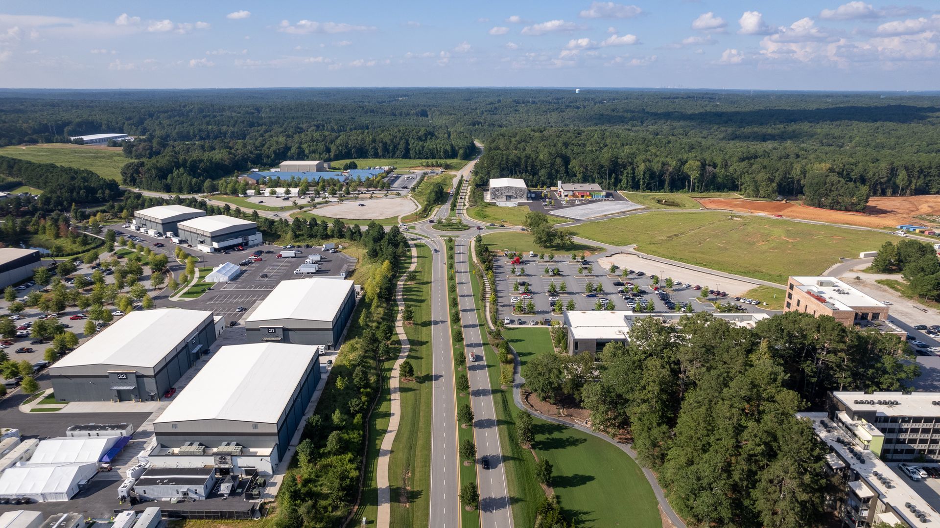 An aerial view of a large industrial area surrounded by trees and buildings.