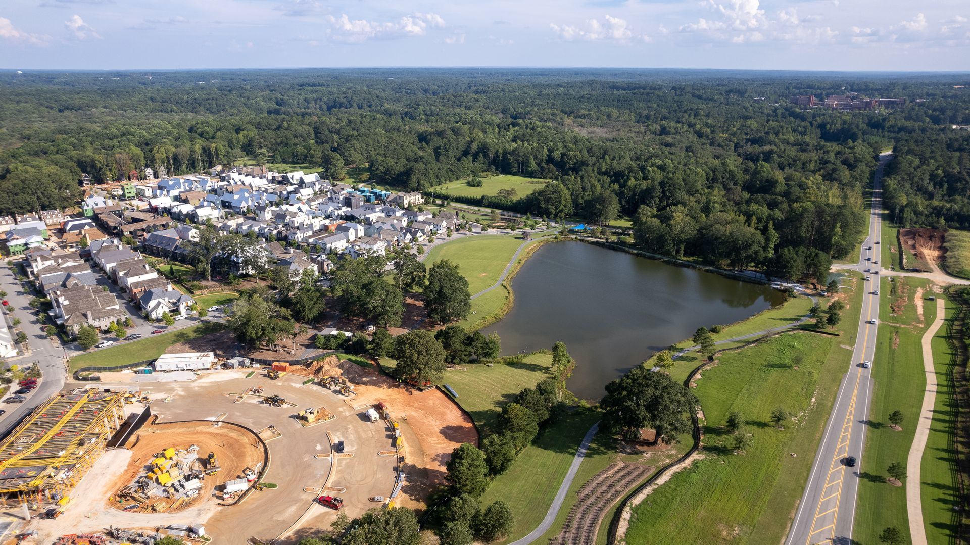 An aerial view of a residential area with a lake in the middle of it.