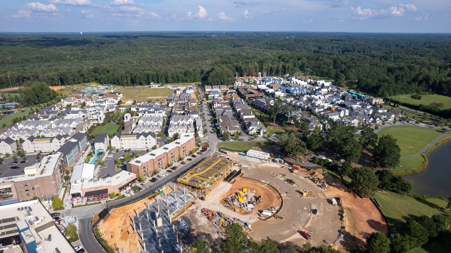 An aerial view of a city surrounded by trees and a lake.