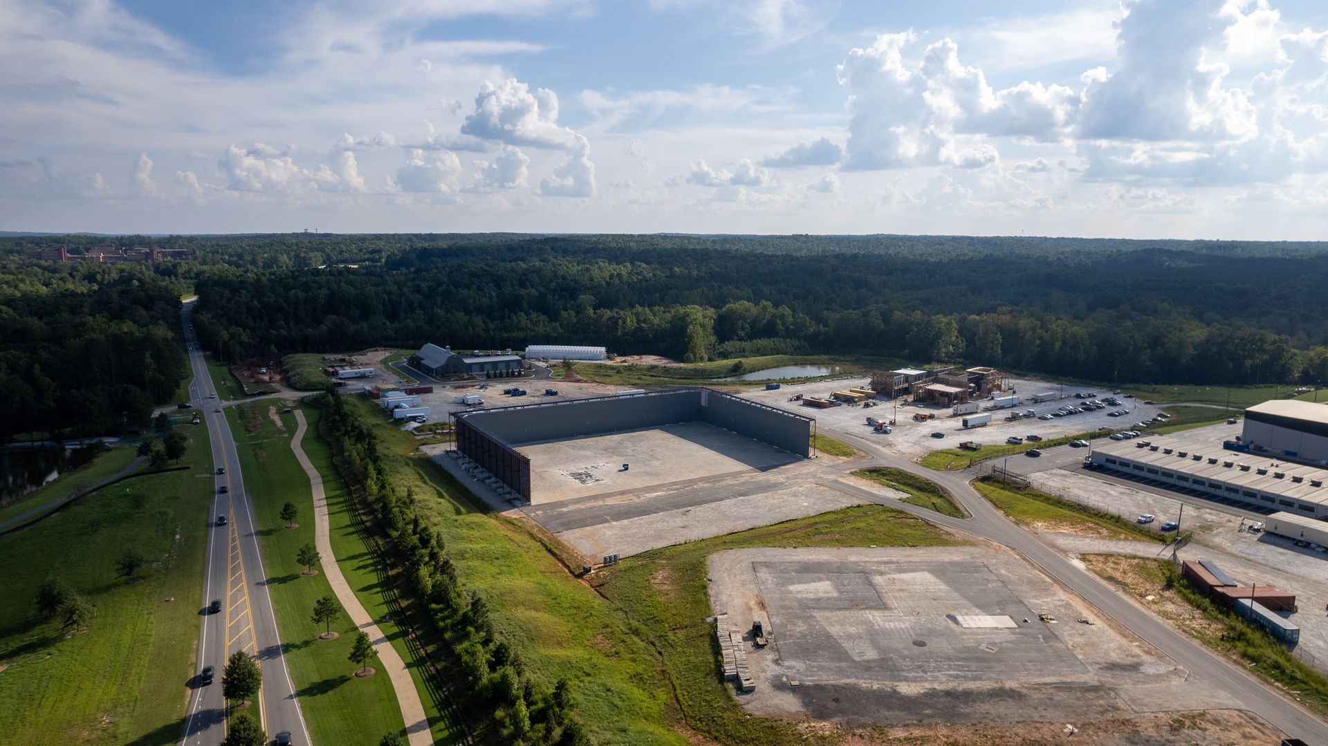 An aerial view of a large industrial area surrounded by trees and buildings.