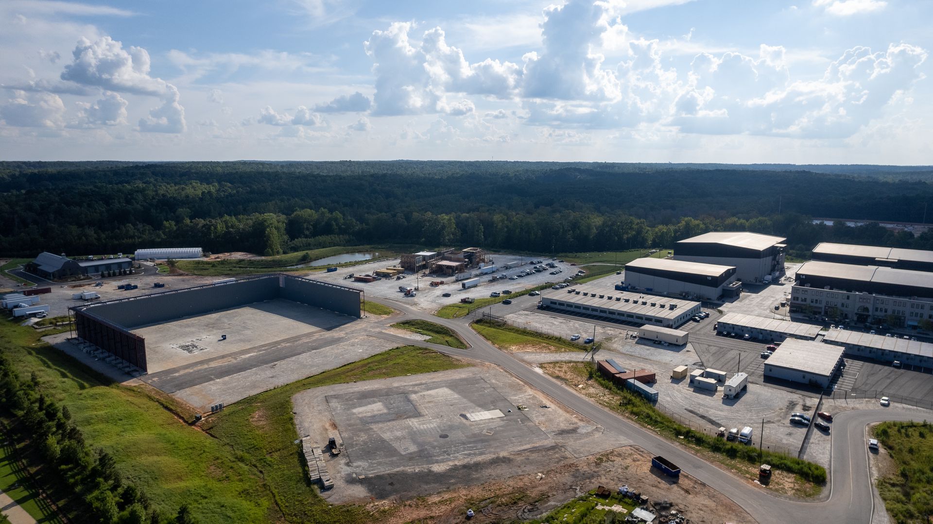 An aerial view of a large industrial area surrounded by trees and buildings.