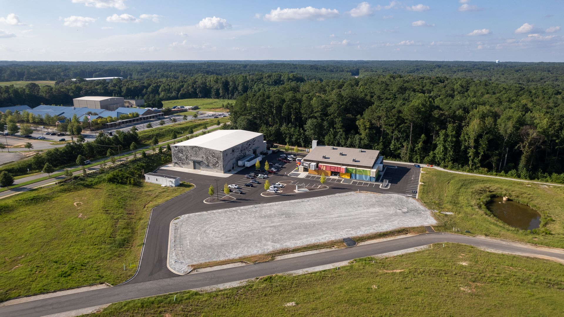 An aerial view of a large building in the middle of a field surrounded by trees.