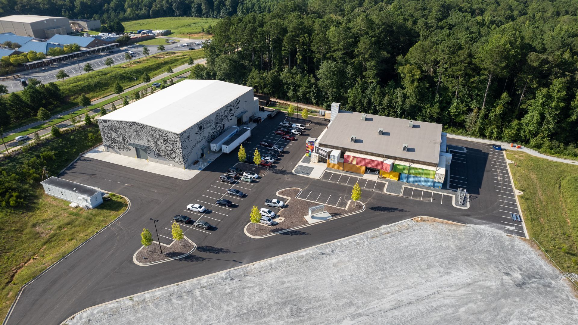 An aerial view of a large building with a parking lot in front of it.