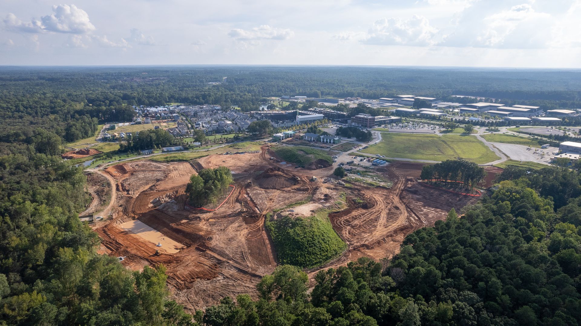 An aerial view of a construction site in the middle of a forest.