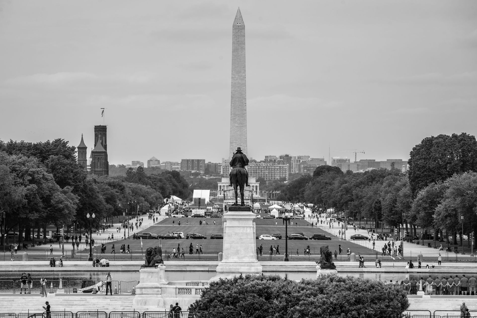 Washington Monument and reflecting pool at the National Mall, with statue centered in the foreground