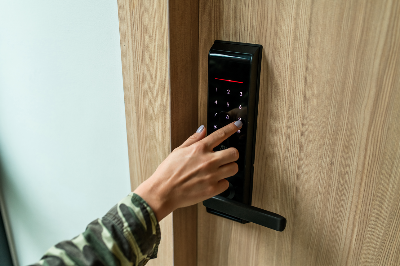 Hand using a digital door lock on a wooden door